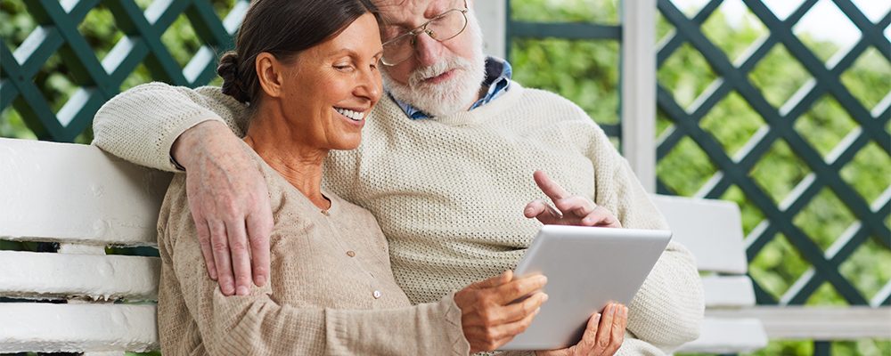 Affectionate seniors using tablet for video talk with friends