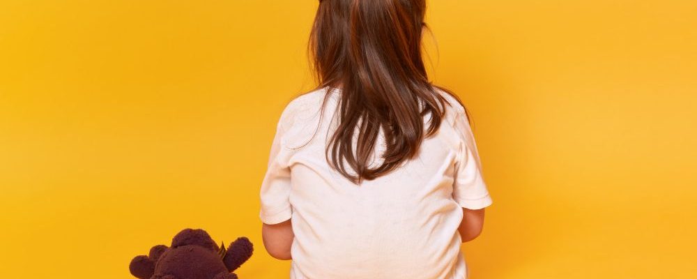 little-girl-sitting-backwards-with-brown-teddy-bear (1)